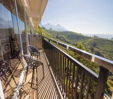 A balcony with a view of a hilly landscape.