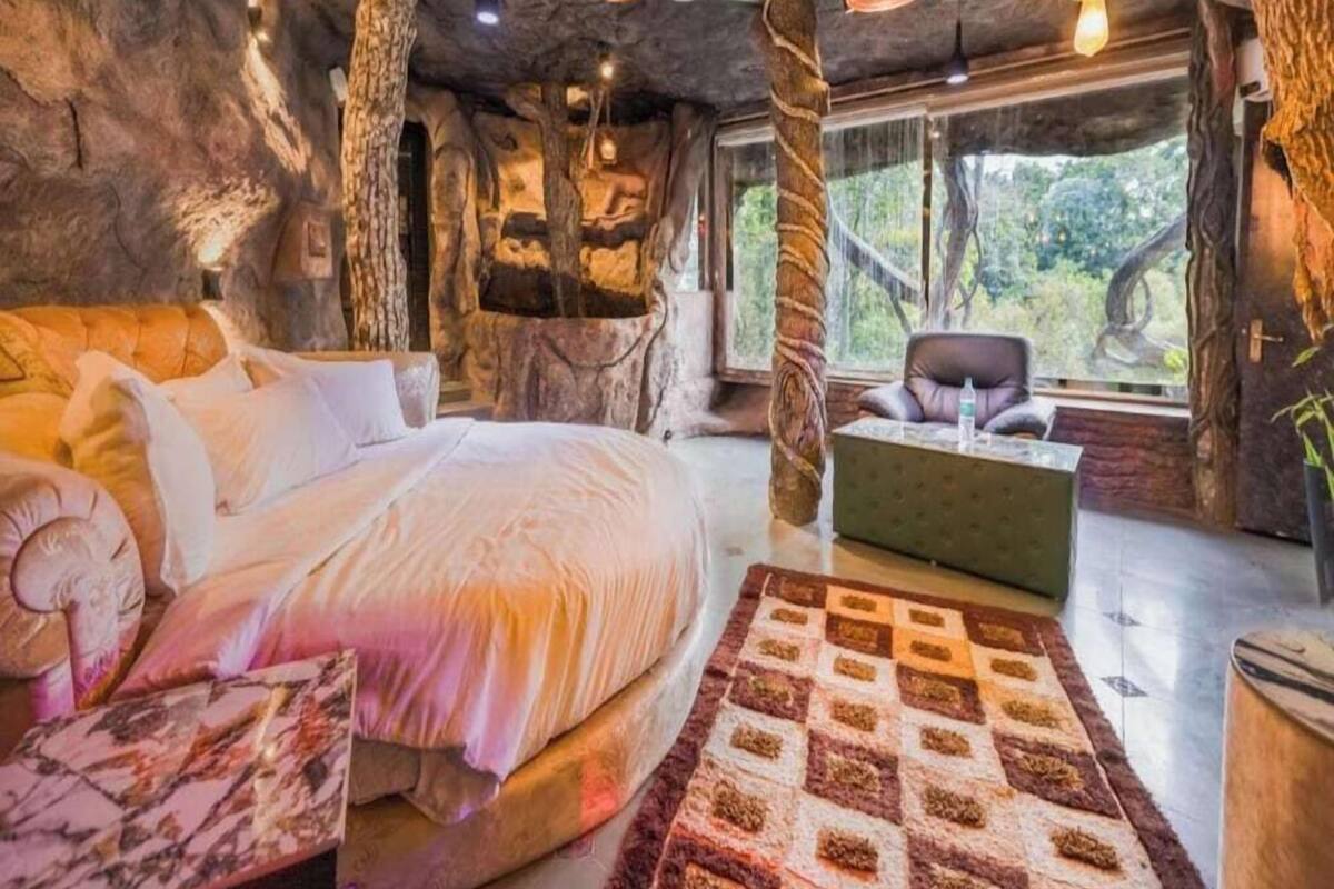 A bedroom with a bed, a chair, a rug, and a window with a view.