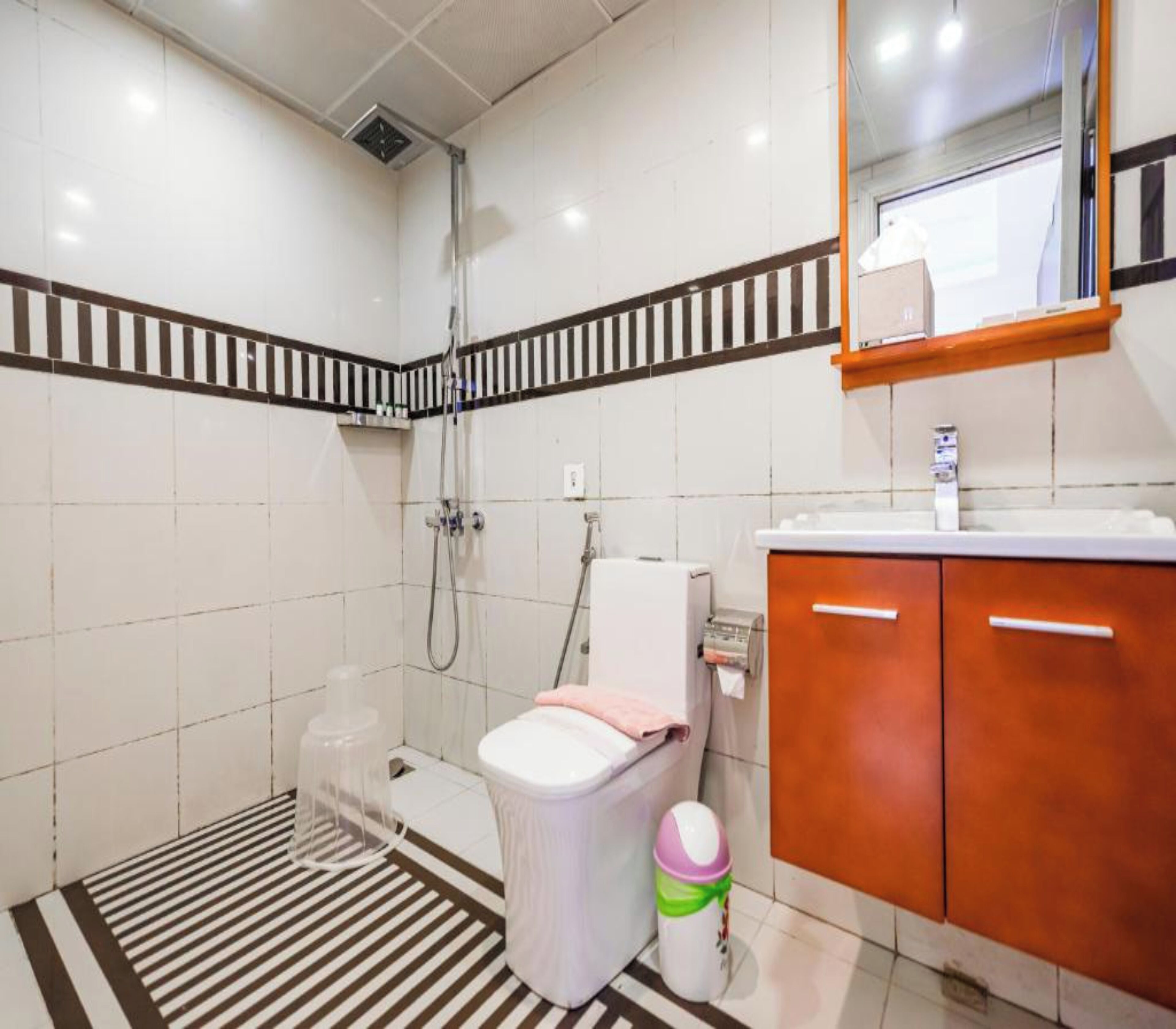 A bathroom with a shower, toilet, and sink.