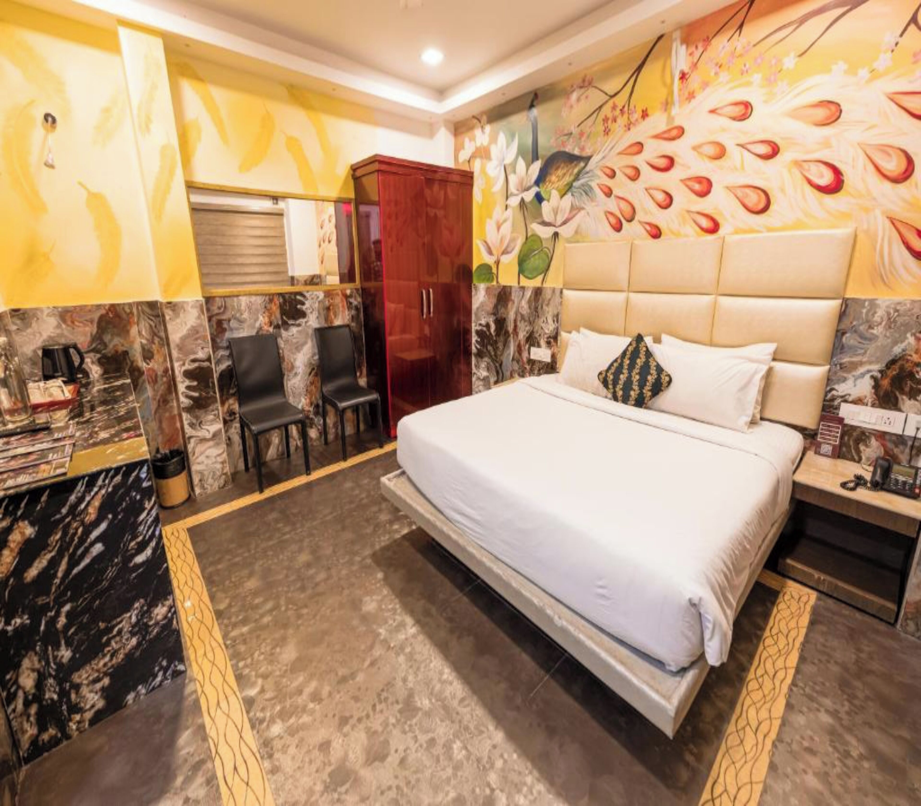 A hotel room with a bed, a desk, a chair, and a wardrobe.