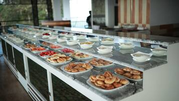 A buffet with various food items displayed on a marble counter.