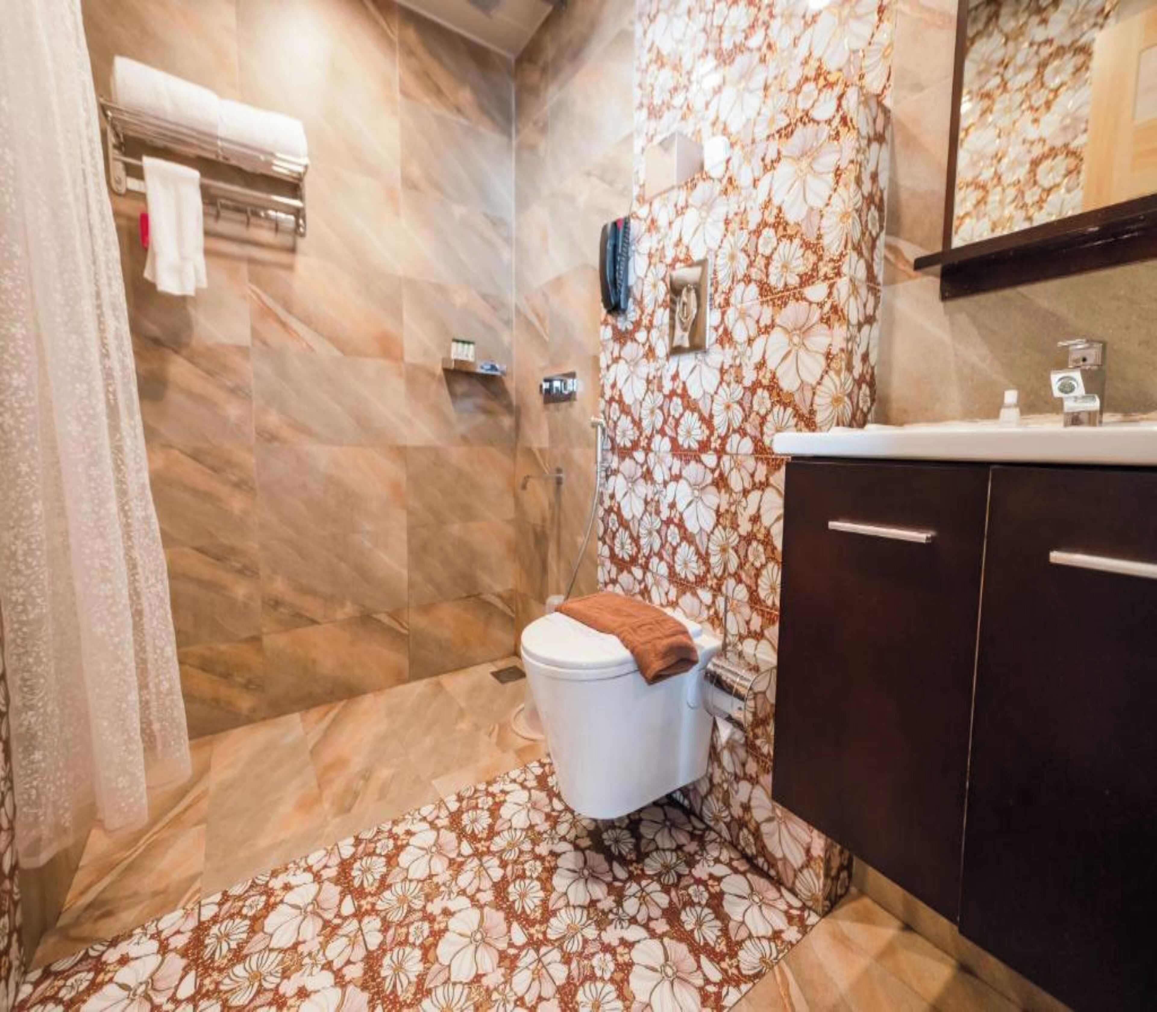 A bathroom with a toilet, a shower, and a sink.