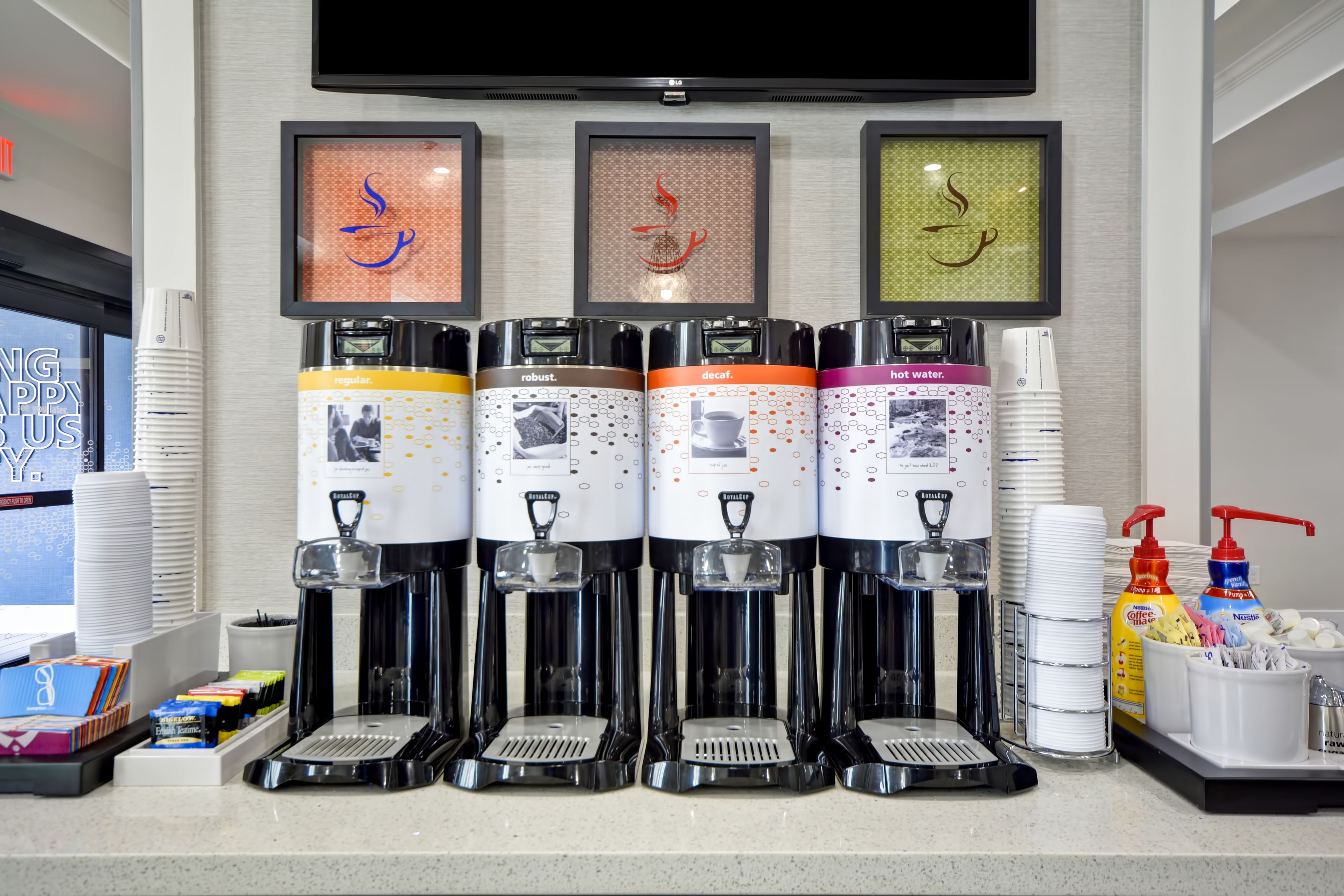 En kaffestation med fyra behållare, var och en märkt med ”vanligt kaffe”, ”starkt kaffe”, ”kaffe utan koffein” och ”varmt vatten”.