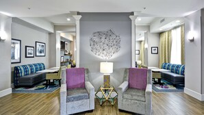 A modern living room with two armchairs, a coffee table, and a wall art piece. - Hampton Inn Kyle (Kyle)