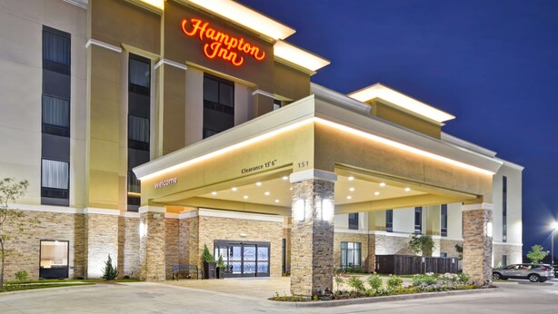 A Hampton Inn hotel with a modern facade, a clear entrance, and a neon sign. - Hampton Inn Kyle (Kyle)