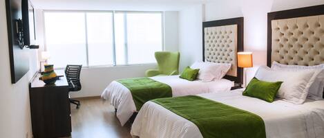 A hotel room with two beds, a desk, a chair, and a large window.