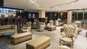 A spacious lobby with plush seating, a bar area, and large windows.