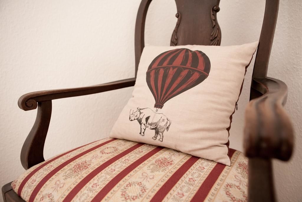 Een stoel met een kussen waarop een luchtballon en een neushoorn afgebeeld zijn.