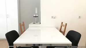 A dining area with a white table, black chairs, and a candle on a stand. - Central Studio Marktplatz (Weimar)