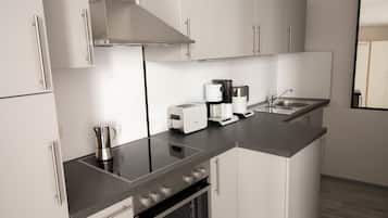 A modern kitchen with stainless steel appliances, a built-in oven, and a countertop with a coffee maker and toaster.