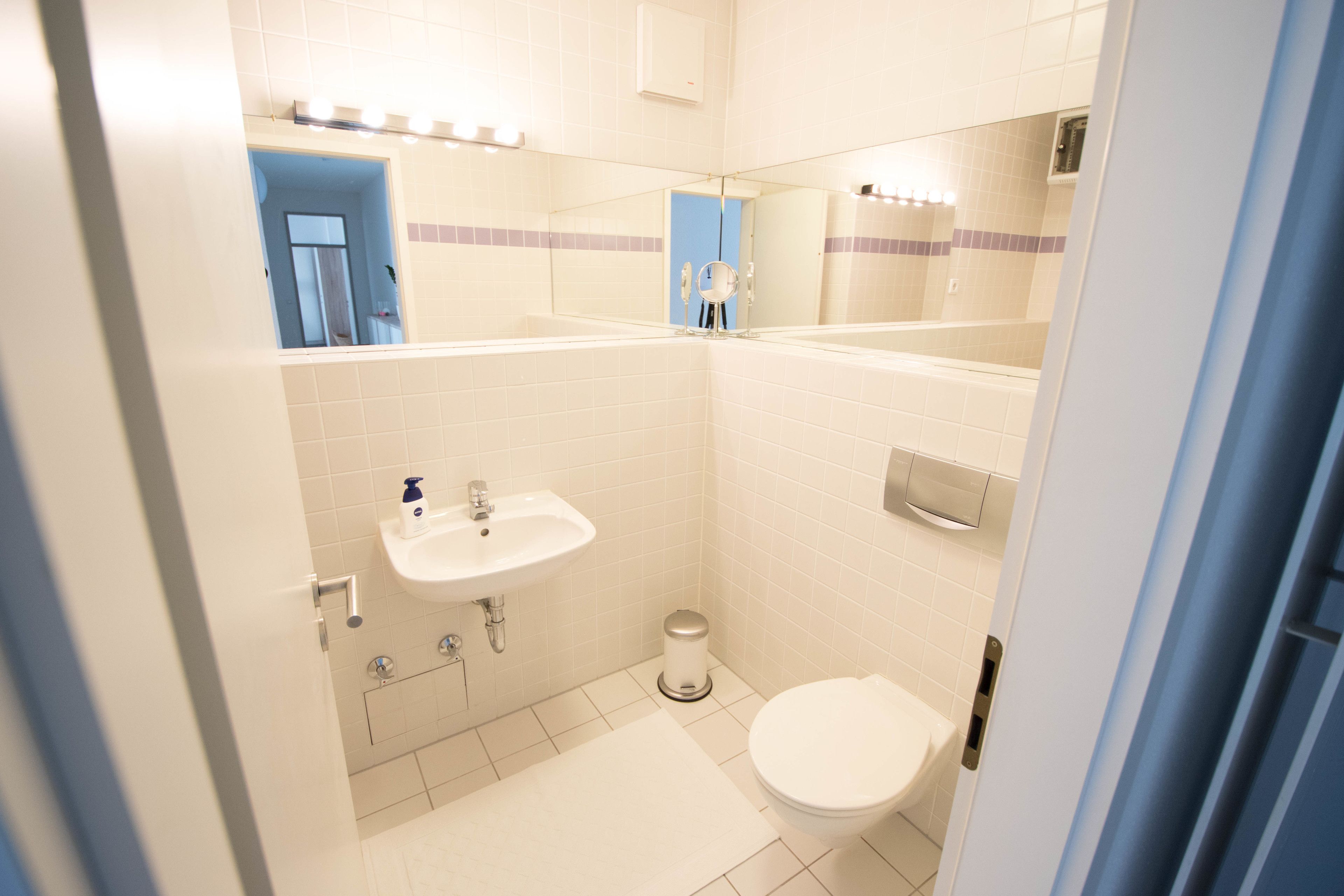 Un baño pequeño con lavamanos, inodoro y espejo.
