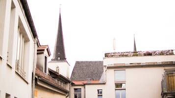 Eine enge Straße mit Gebäuden, darunter eine Kirche mit einem hohen Kirchturm und ein Gebäude mit einem geneigten Dach.