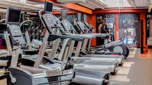 Ett gym med flera löpband, alla utrustade med digitala displayer och tillverkade av märket ”Life Fitness”.