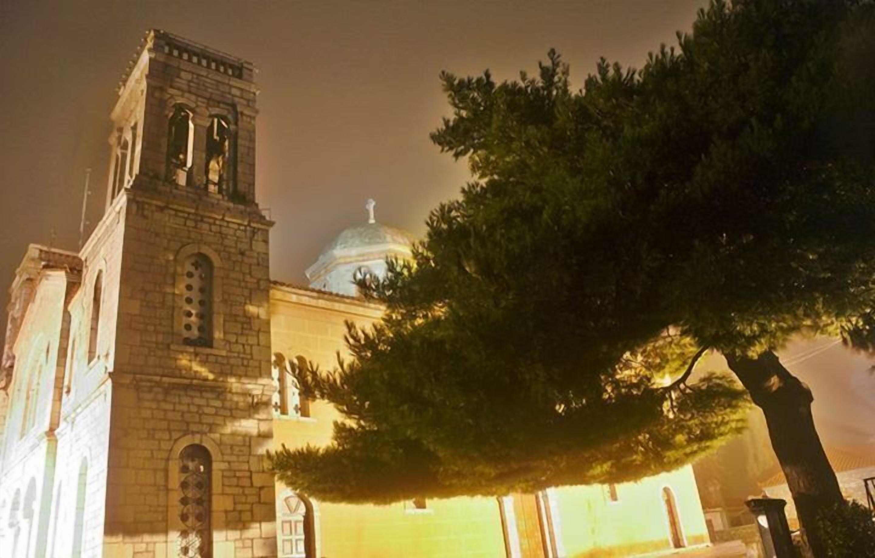 A church with a bell tower and a dome, surrounded by trees.