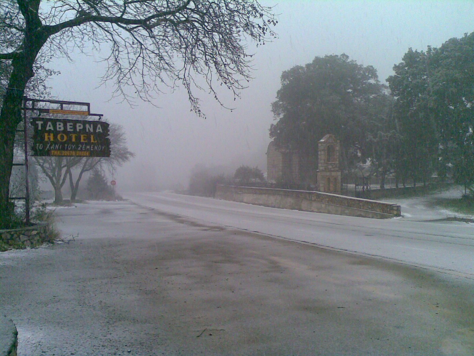 A snow-covered road with a sign for the Tabepna Hotel.