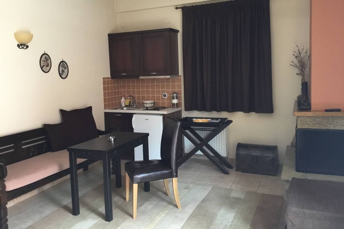 A compact living space with a kitchenette, a dining area, and a seating area.