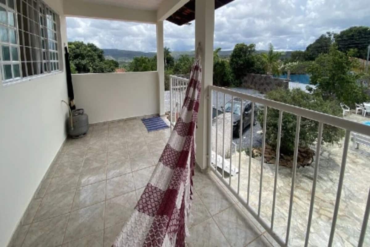 Un balcó amb vista a una piscina i vegetació, un terra de rajola i una barana.