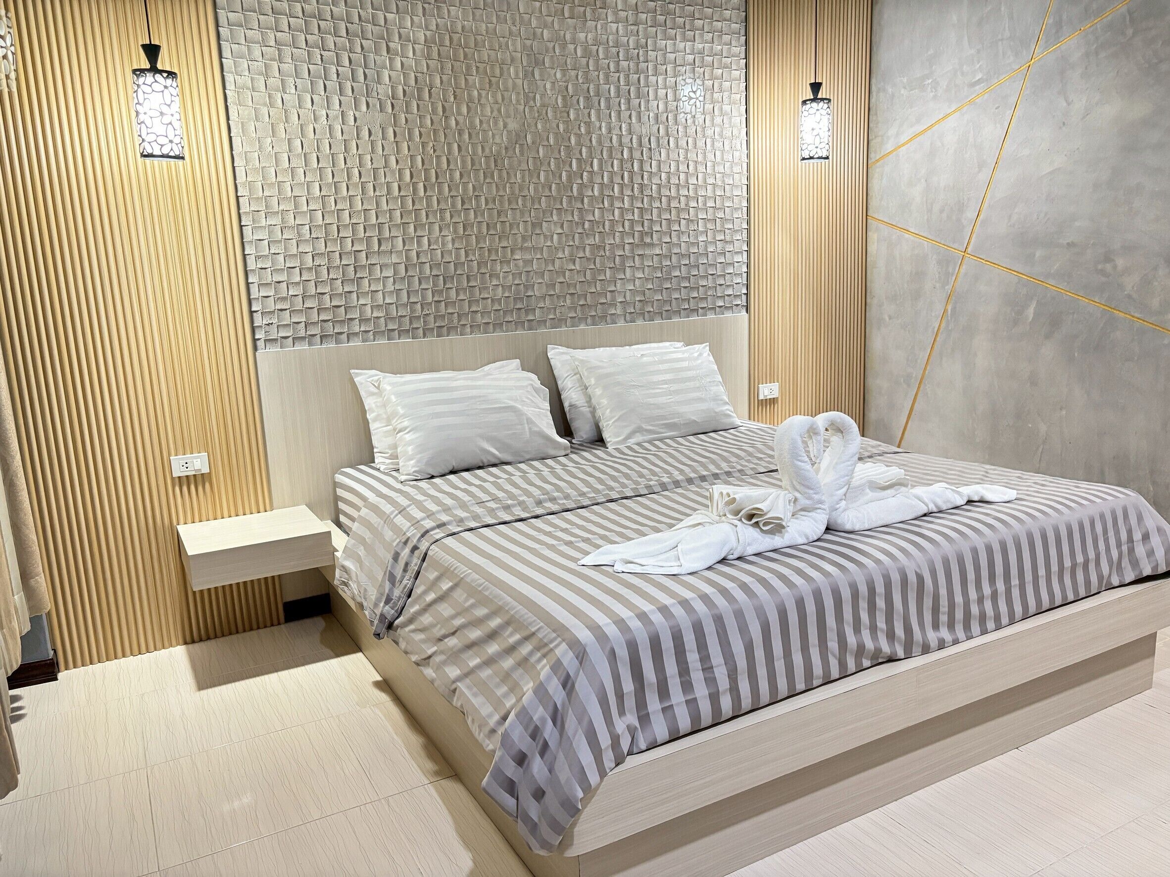 Una camera da letto moderna con un letto grande, una testiera in legno e un muro strutturato.