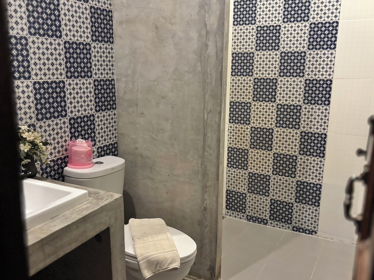 A bathroom with a toilet, sink, and shower area.