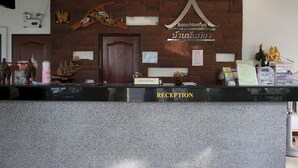 Balcão de atendimento com placa, porta de madeira e parede de tijolos com detalhes decorativos.