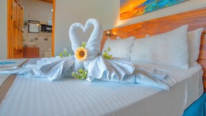 Una habitación de hotel con cama, un cuadro en la pared y un baño visible a través de una puerta abierta.