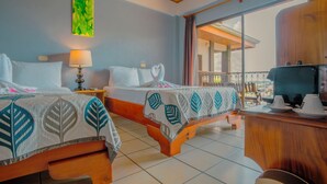 Habitación de hotel con dos camas, techo de madera, ventana grande con vistas y un escritorio pequeño con una lámpara.
