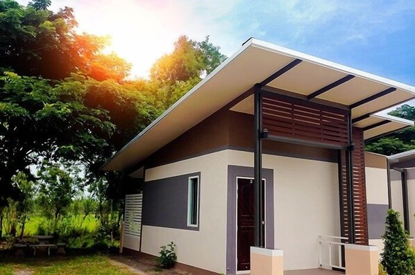 A modern two-story house with a flat roof, large windows, and a covered porch. - The Premium Resort (Suwannaphum)