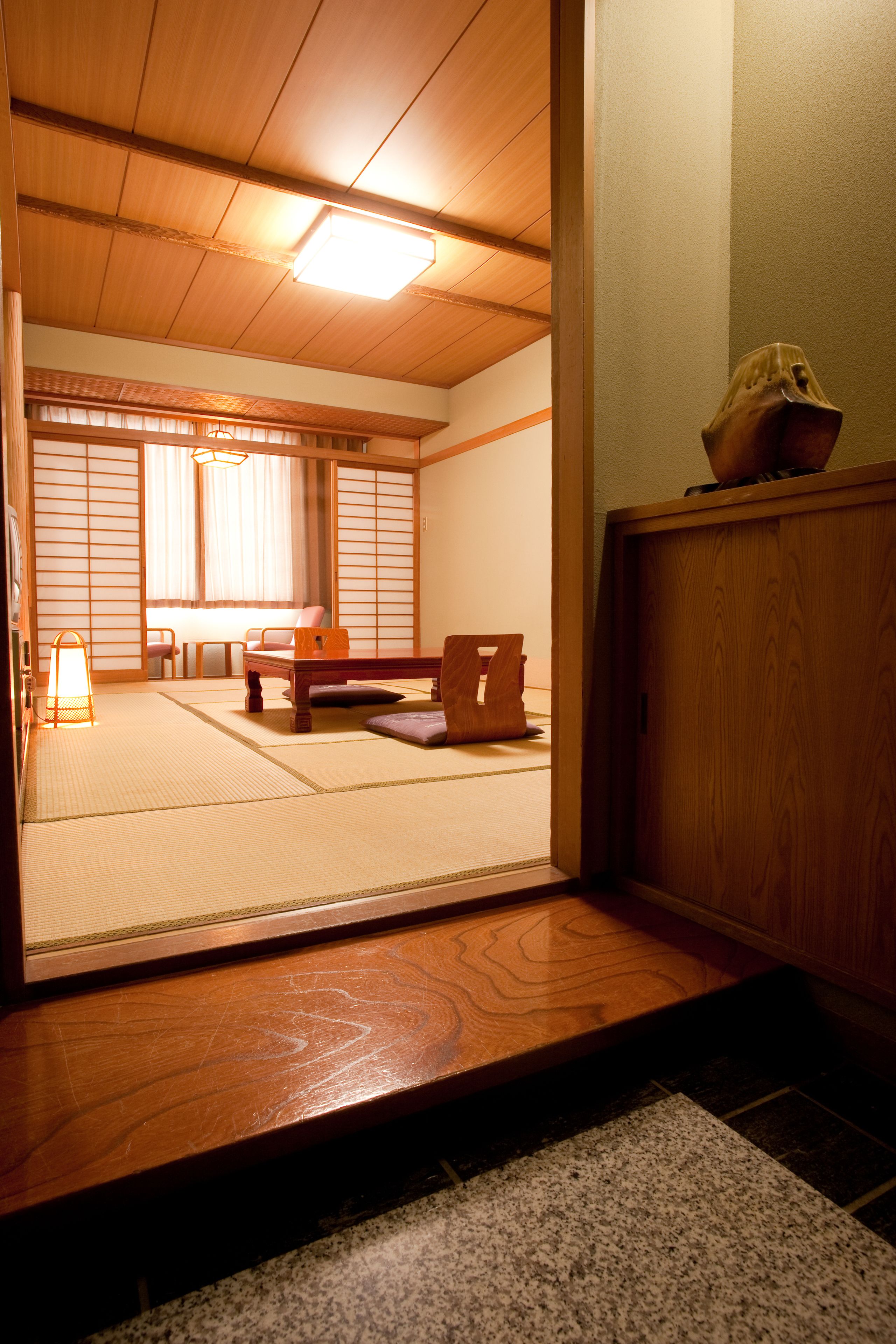 Una habitación tradicional japonesa con suelo de tatami, una mesa de madera baja y un puertas correderas.