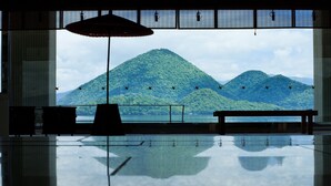 Una habitación con un amplio ventanal con vistas a un paisaje montañoso.