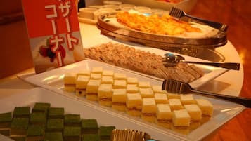 A buffet with various desserts and a sign with Japanese text.