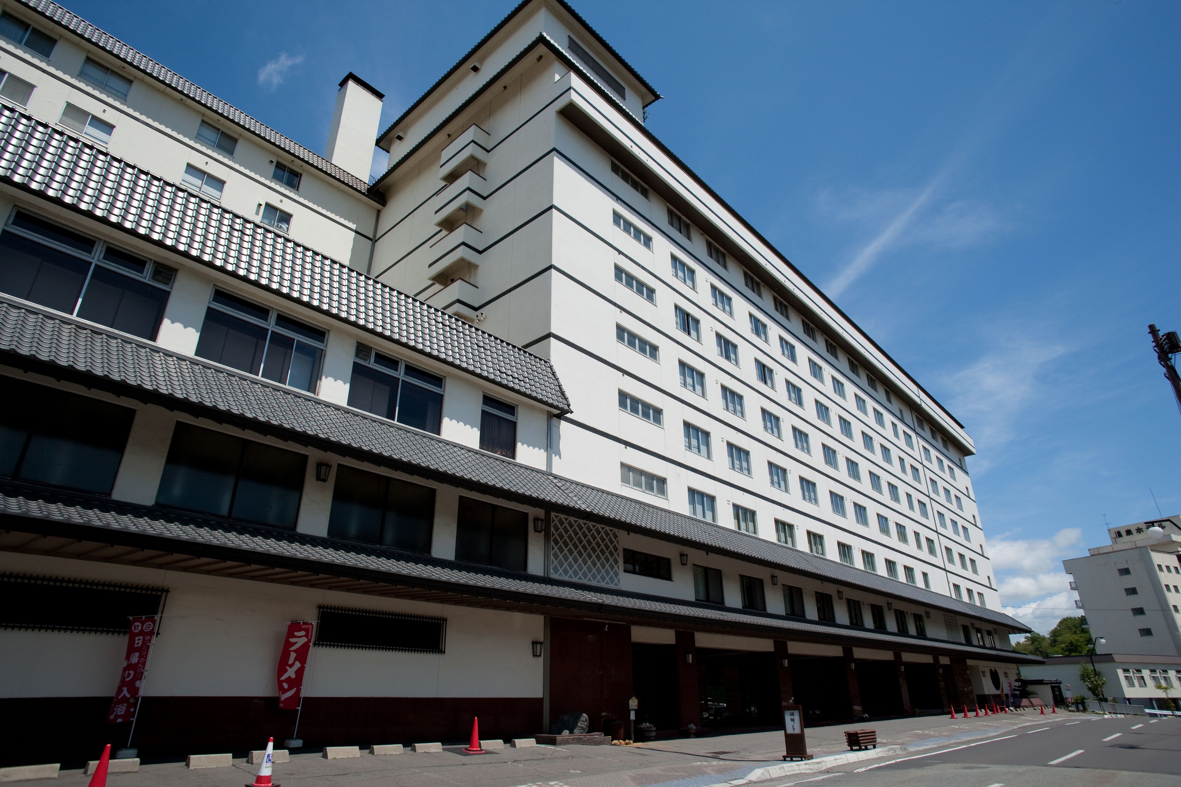 Een hotel met meerdere verdiepingen in traditionele bouwstijl, met een betegeld dak en diverse balkons.