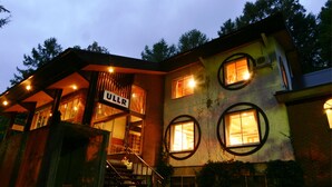 A multi-story building with a sign reading "ULLR" at the entrance. - Pension ULLR (Hakuba)