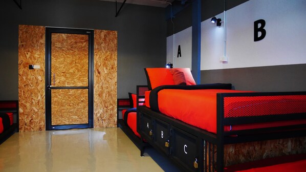 A modern bedroom with a large bed, a wardrobe, and a door with a wooden panel design. - Amity Poshtel - Hostel (Krabi)