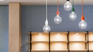 A modern interior with hanging spherical light bulbs and a wooden shelf unit.