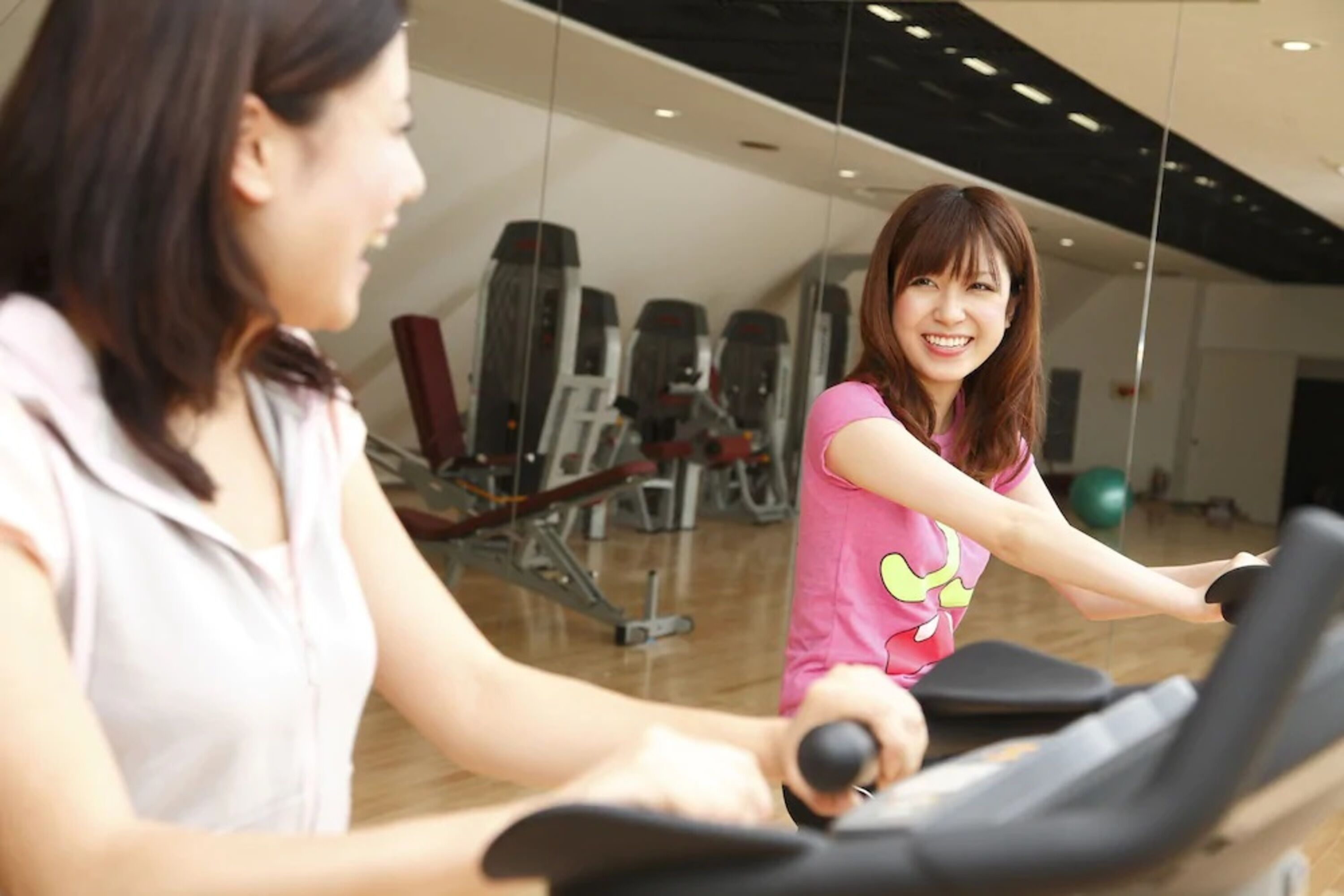 Un gimnasio con equipo de ejercicio y un espejo grande.
