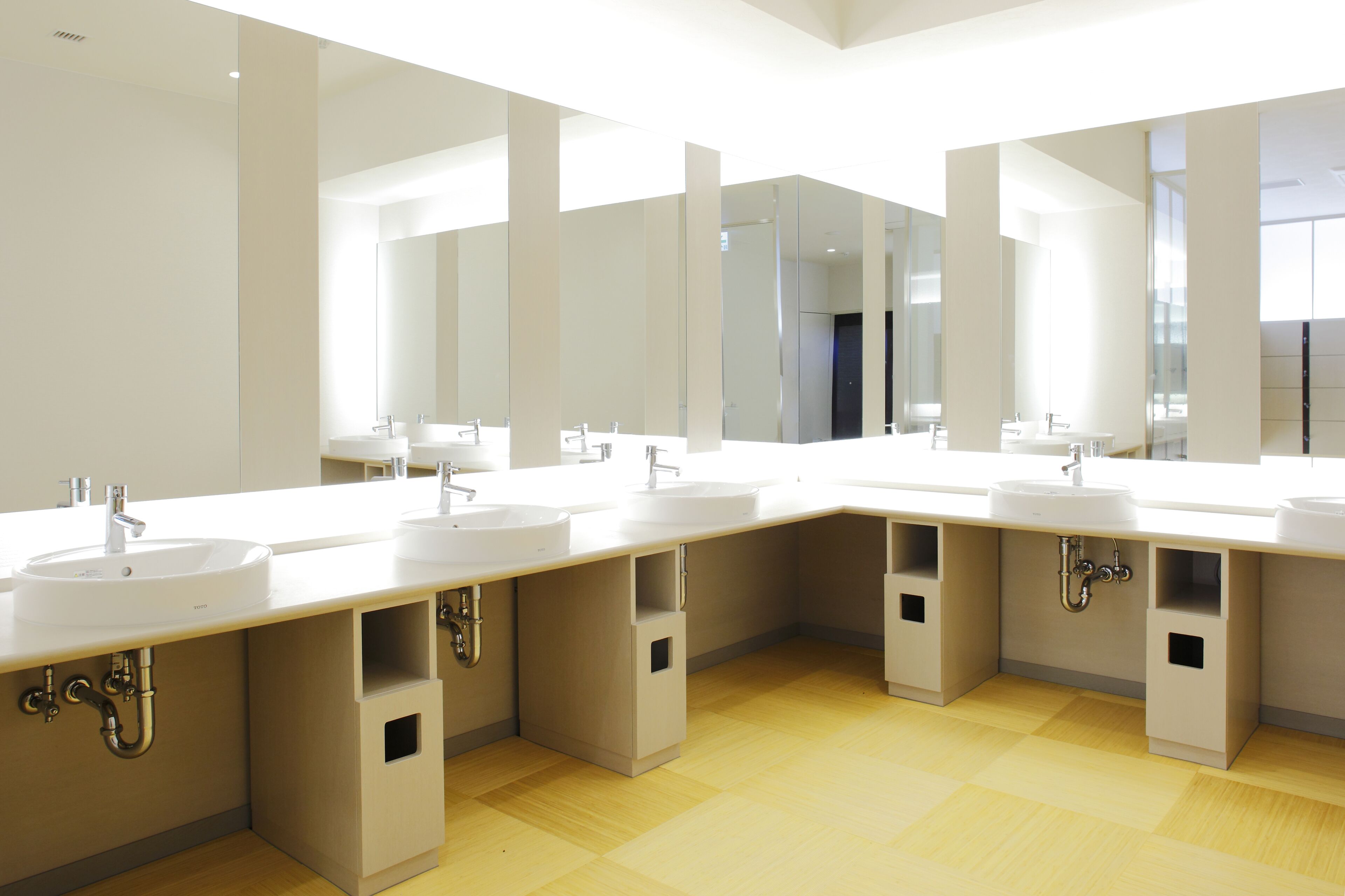A modern bathroom with multiple sinks and mirrors.