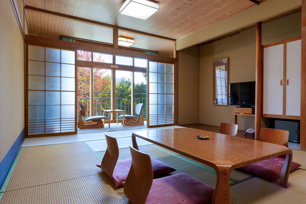 A traditional Japanese room with tatami flooring, a low table, and sliding doors.