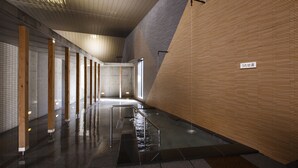 A modern indoor space with a wet floor, wooden columns, and a tiled floor. - Horohoro Sanso (Date)