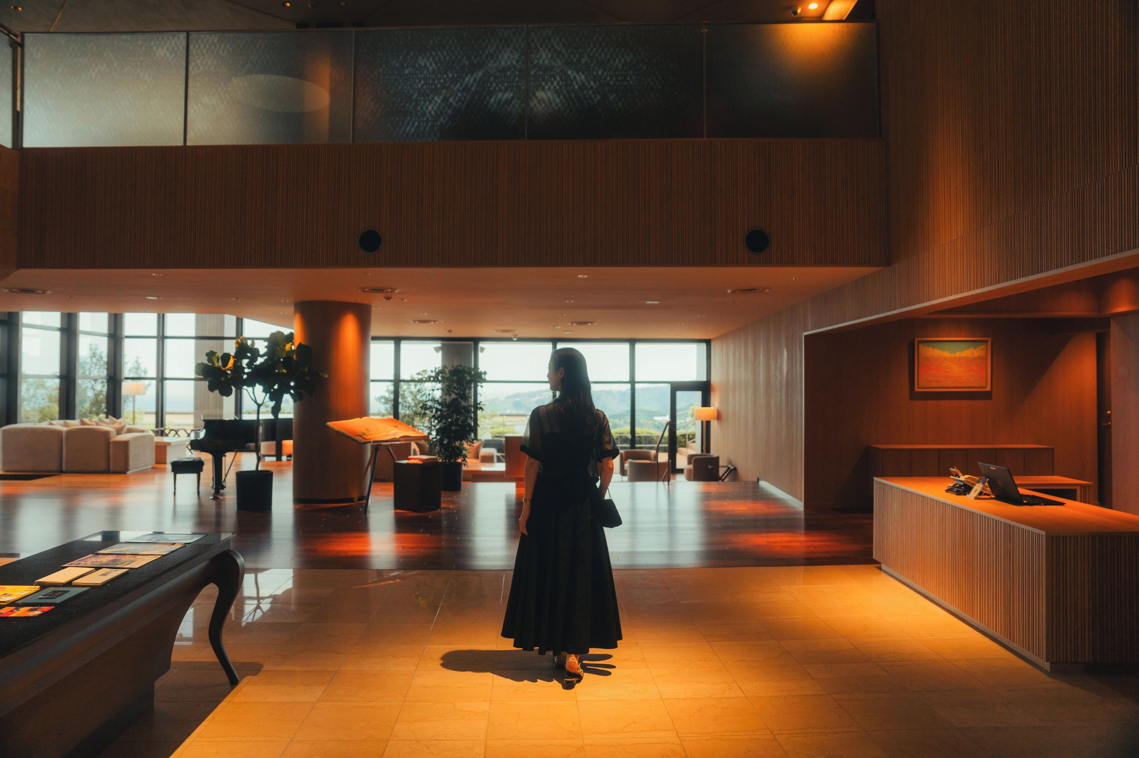 A spacious lobby with a reception desk, seating area, and large windows offering a view.