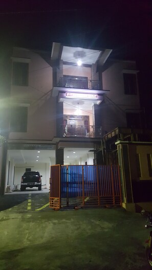 A multi-story building with a balcony and a garage entrance. - Griya Rambutan Barat (Semarang)