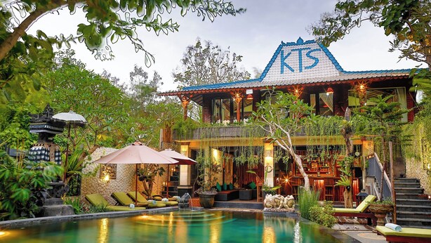 Un resort con piscina, zonas de descanso y bar.