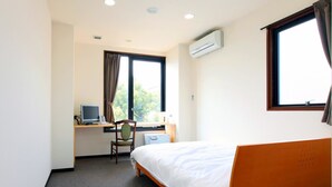 A hotel room with a single bed, a desk with a computer, a chair, and a window with curtains. - Sakaide Plaza Hotel (Sakaide)