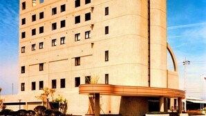A modern hotel with a curved facade, multiple floors, and a prominent entrance area. - Sakaide Plaza Hotel (Sakaide)