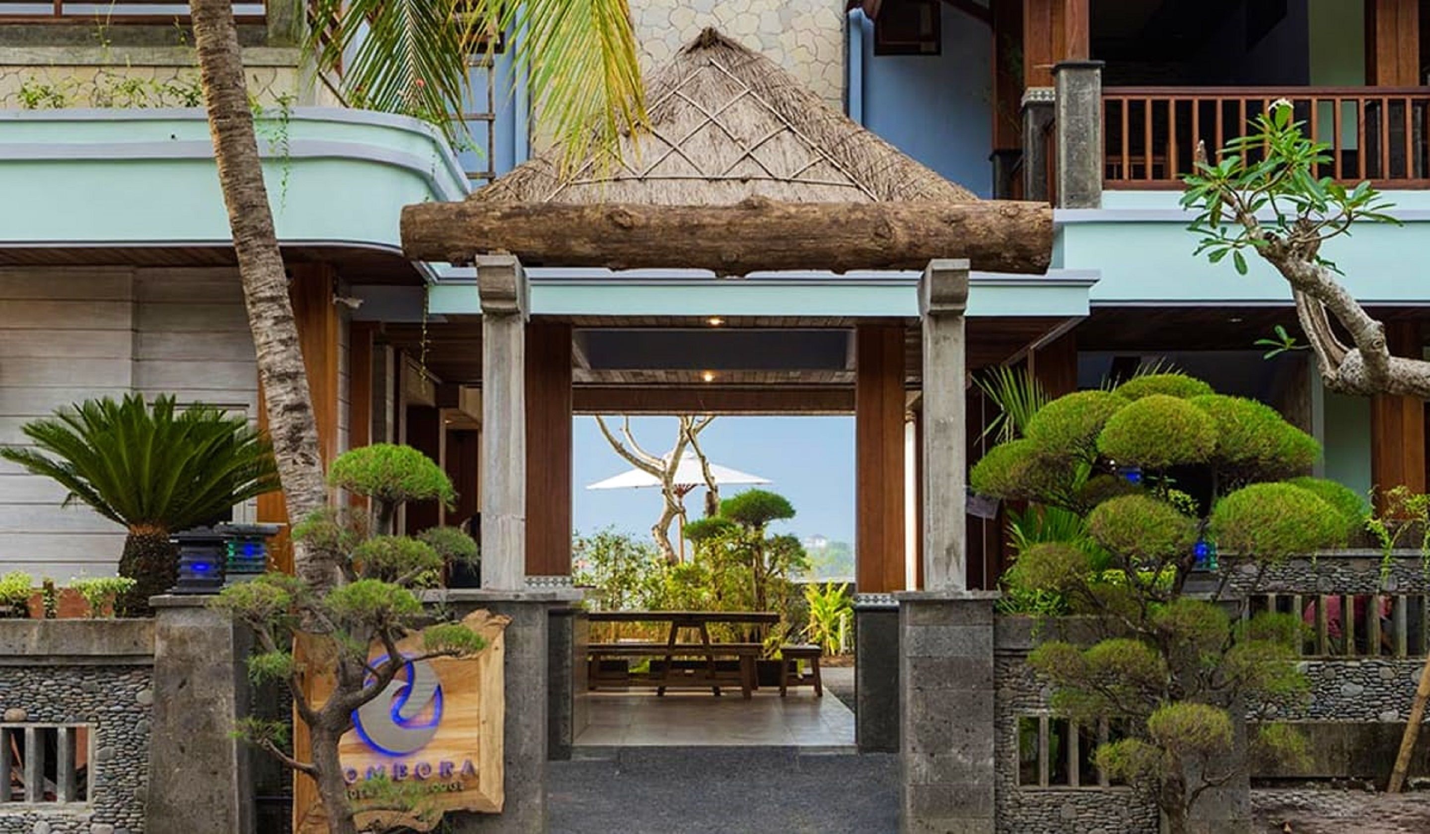 A traditional building with a wooden entrance canopy, stone walls, and a signboard.