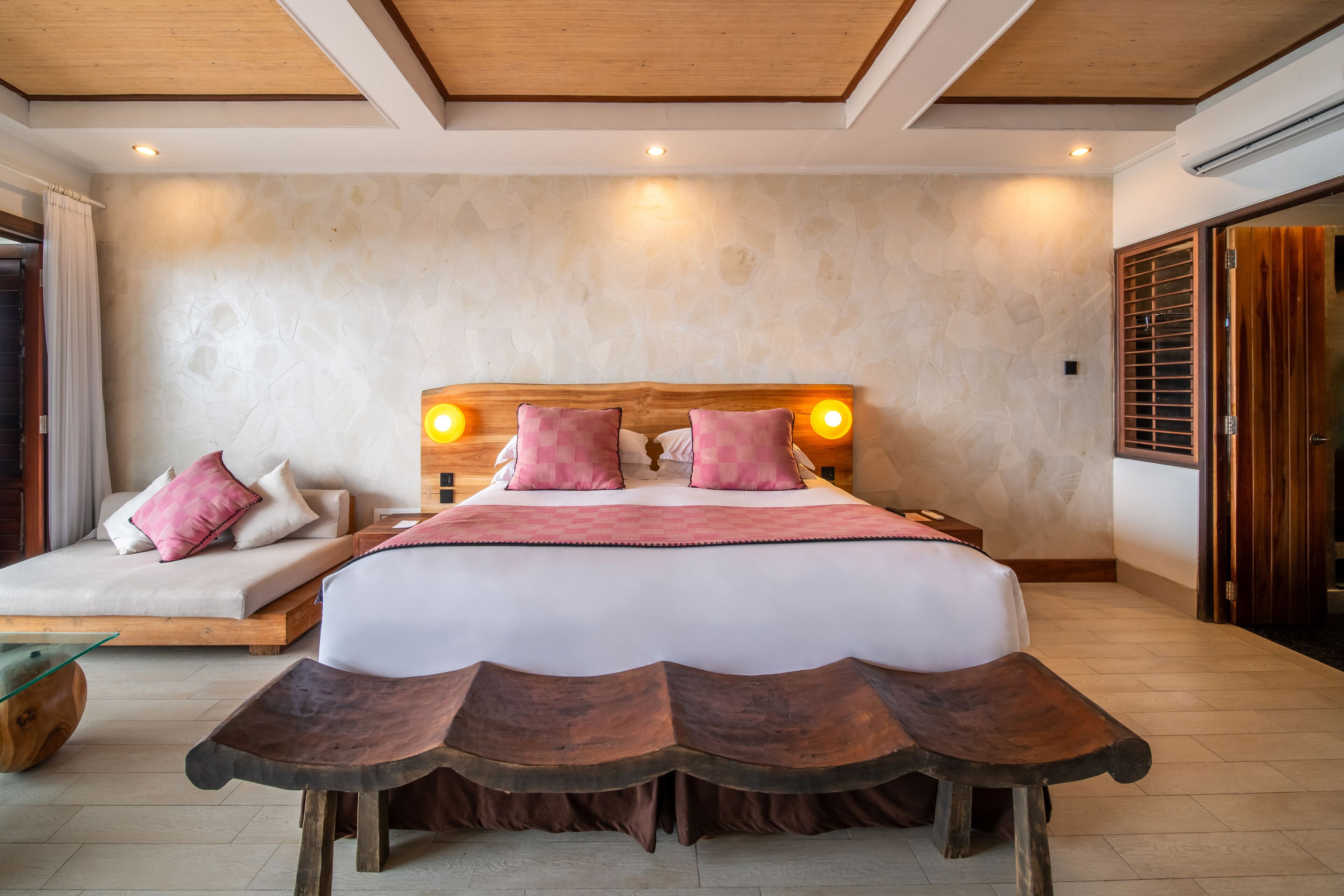 A bedroom with a large bed, wooden headboard, and bedside lamps.