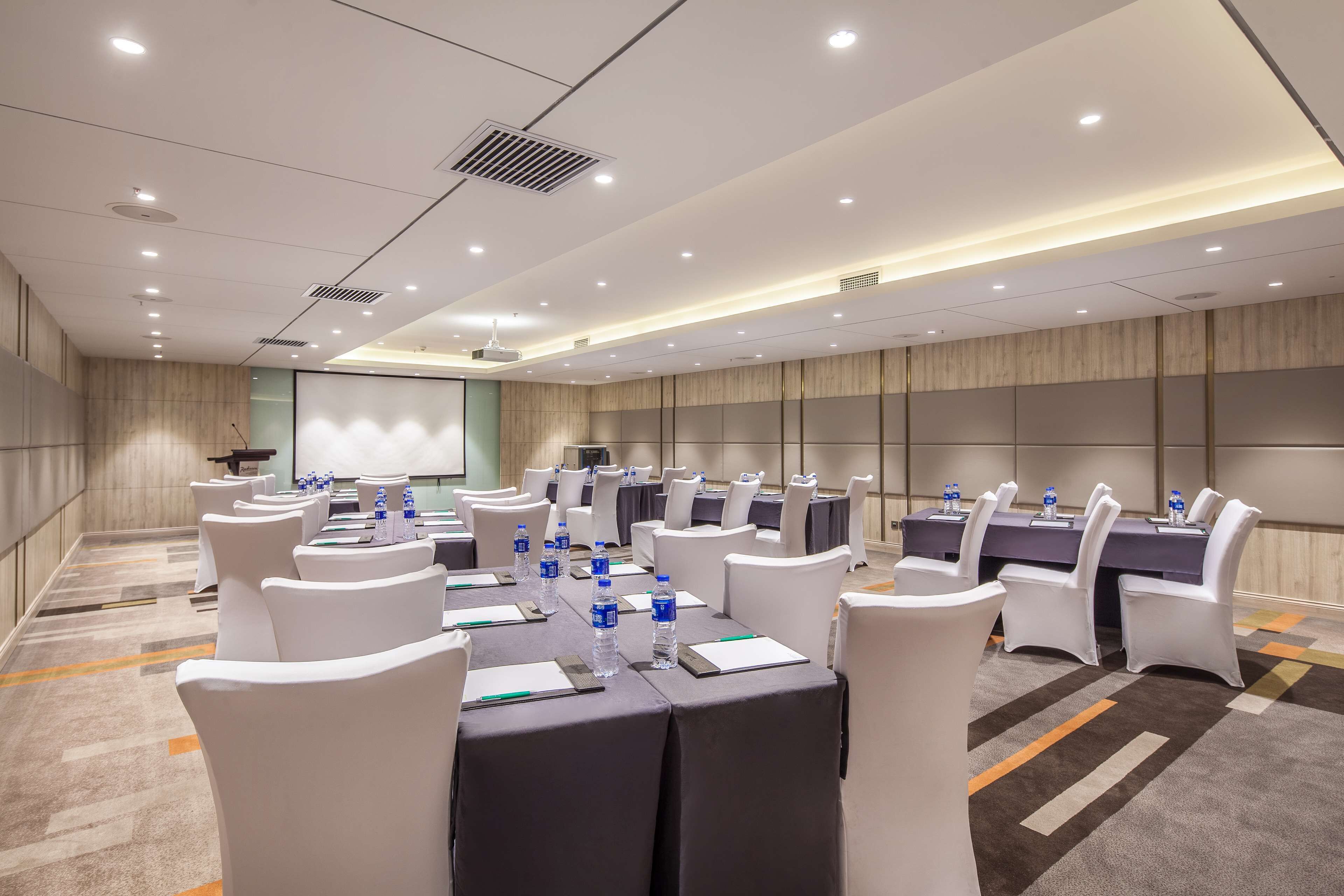 A conference room with tables, chairs, and water bottles.