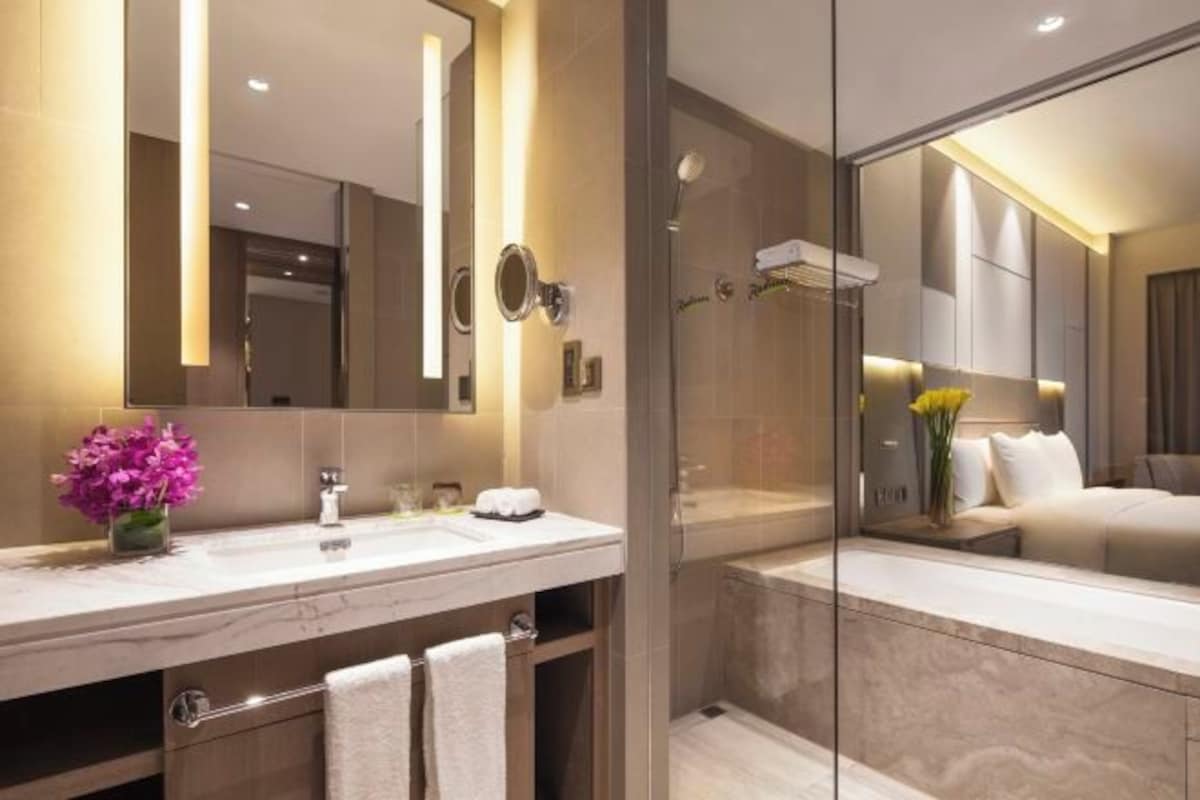 Une salle de bain moderne avec un grand miroir, un meuble-lavabo et un espace douche.