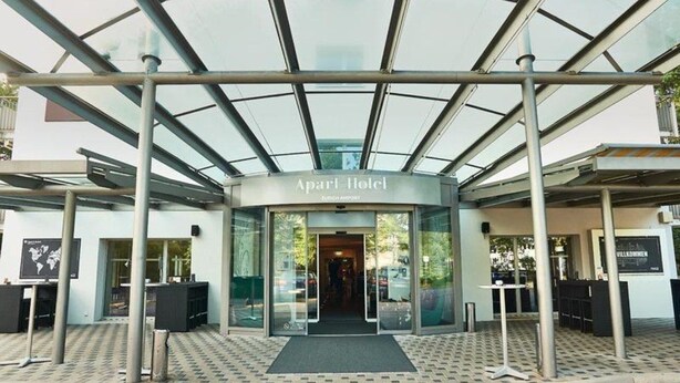 The entrance to the Apart Hotel with a modern glass canopy and a welcoming entrance. - Apart Hotel Zurich Airport (Opfikon)