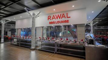 Un interior de restaurante moderno con un letrero destacado que dice "RAWAL BBQ LOUNGE".