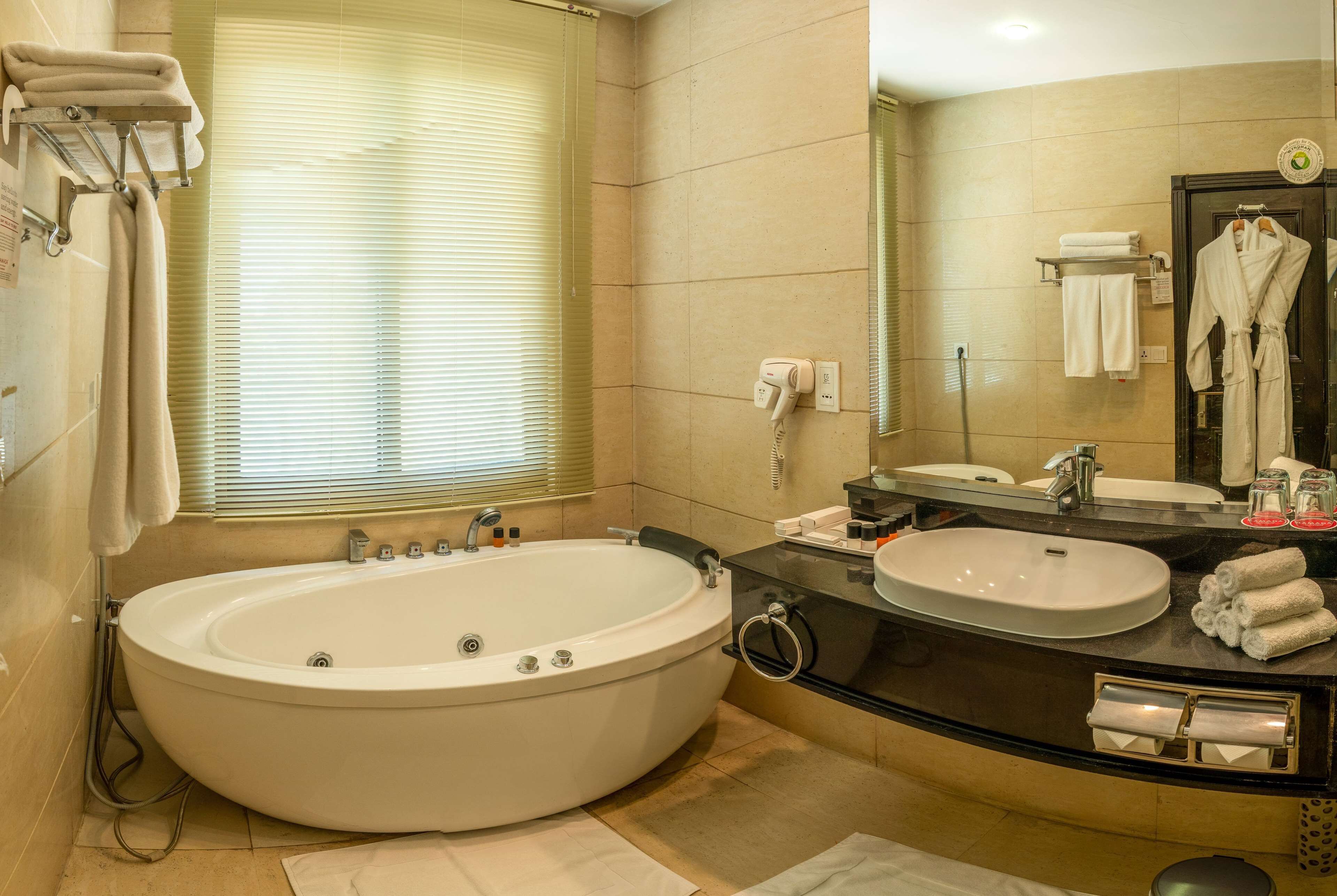 A modern bathroom with a large bathtub, two sinks, and a vanity.